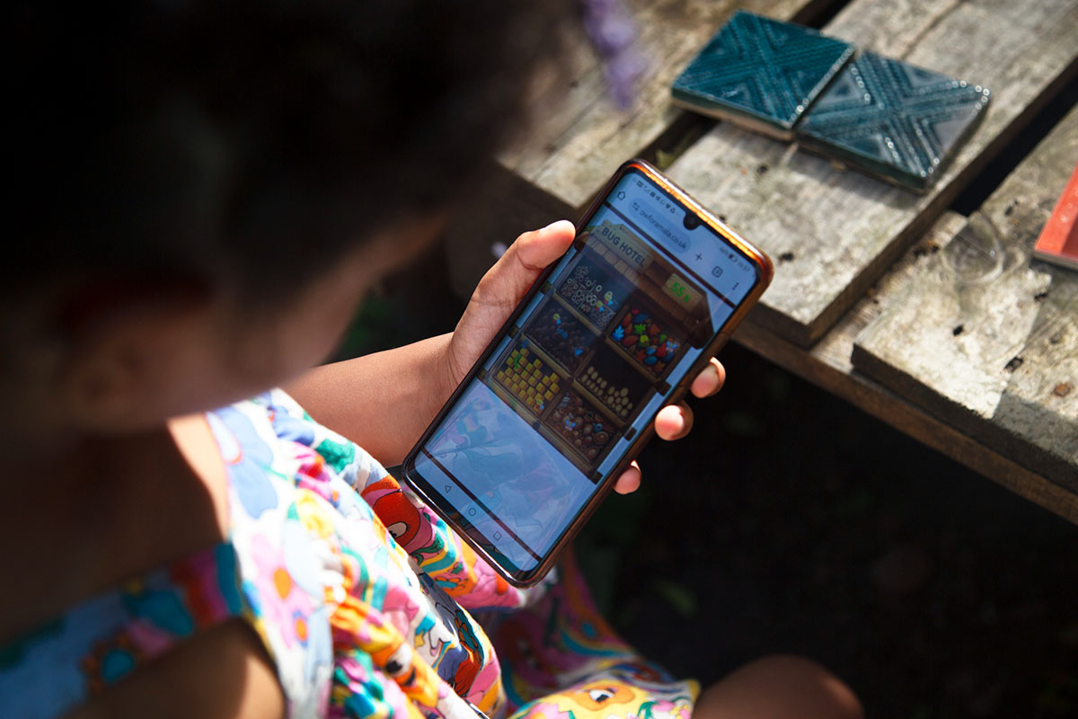 A young person is looking at a game on a mobile phone