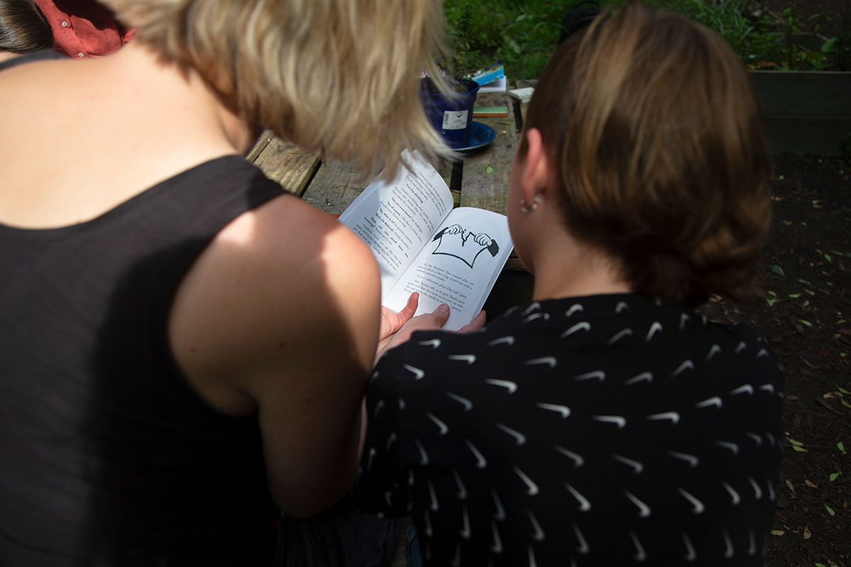 An adult reads the book with a young person