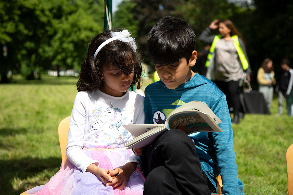 Two young people read a book together